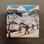 Magnet illustration print of skiers in a snowy landscape with trees on a metallic surface.