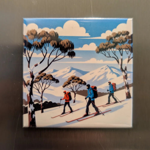 Magnet illustration print of skiers in a snowy landscape with trees on a metallic surface.